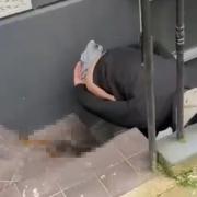 A man is defecating outside a property in Charlotte Street