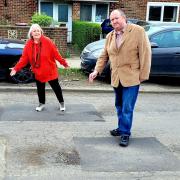 Cllr Cornell and council leader Michael Jones pointing at the failing repairs