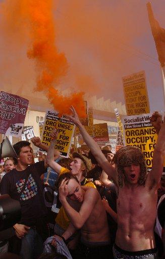 Orange smoke fills the air as flares were let off during the Anti Government protest outside the Labour Party Conference in Brighton today.