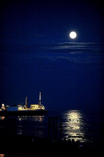 A full moon shines down on Brighton seafront over the Palace Pier. August 2009