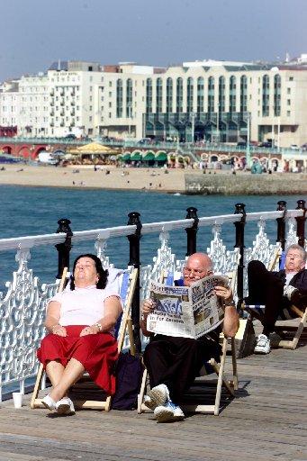 Michael Stevens and his wife Valerie from Preston Park in Brighton enjoy the weather and reading their favourite newspaper on a visit to Palace Pier on Good Friday, 2002.