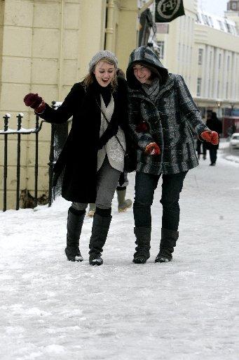 Lizzie Banfield, 22, and Anna Roberts, 22, struggle to walk down Western Road, Hove, in the heavy snow