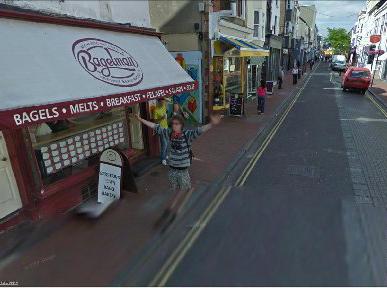 A man waves at the Google car as it travels along Bond Street in Brighton
