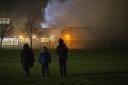 Youngsters watch on as their school goes up in flames