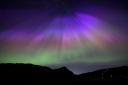 The aurora borealis, also known as the northern lights, above Arthur’s Seat and Salisbury Crags in Holyrood Park, Edinburgh (Jane Barlow/PA)