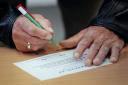A man marks a ballot paper