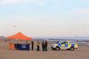 Police officers at Camber Sands near Rye, after five young men died