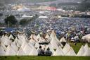 Campers attempt to escape the rain at Glastonbury Festival in Somerset