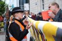 A protester speaks to a police officer outside Barclays in Brighton