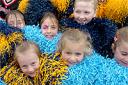 Southern Knights cheerleaders huddle to keep warm in the damp weather