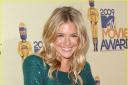 Sienna Miller looks party-perfect in a jewel-coloured dress