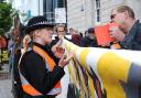 A protester speaks to a police officer outside Barclays in Brighton