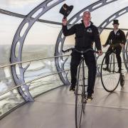 Neil Laughton, front, and Mark Newman, riding their penny farthings around the i360 in Brighton