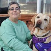 Elaine Moore and her assistance dog Bentley outside the Living Well Centre on Brighton seafront