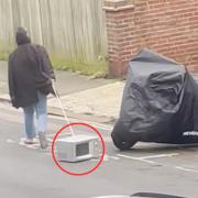 The woman walking the microwave along Lorna Road