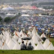 Campers attempt to escape the rain at Glastonbury Festival in Somerset