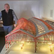 Malcolm standing next to his giant replica