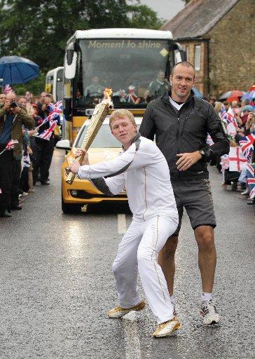 Dominic Raeyen carrying the Olympic Flame on the Torch Relay leg between Petersfield and Easebourne.