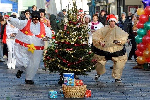Charity fundraisers went running along New Road, Brighton taking Christmas puddings through an assault course