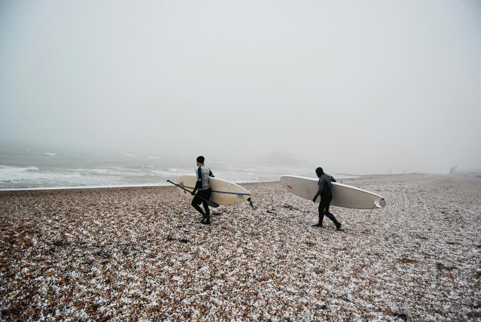 Great photo of brave surfers heading into the water off Brighton beach this morning by @EddieYeah
