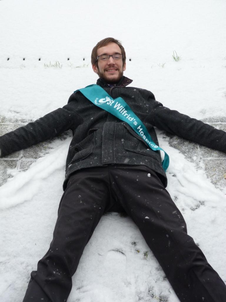 Database manager, Nigel Cloutt, making a snow angel in the St Wilfrid's Hospice garden in his lunch break