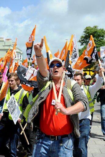 Striking Brighton Cityclean workers and GMB Union members march through the city in protest at the proposed cuts to their take home pay by Brighton and Hove City Council . The binmen have been on strike since Friday and are expected to be out for a week
