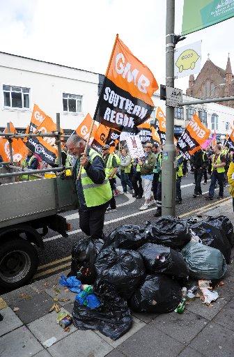 Striking Brighton Cityclean workers and GMB Union members march through the city in protest at the proposed cuts to their take home pay by Brighton and Hove City Council . The binmen have been on strike since Friday and are expected to be out for a week