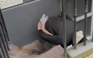 A man is defecating outside a property in Charlotte Street