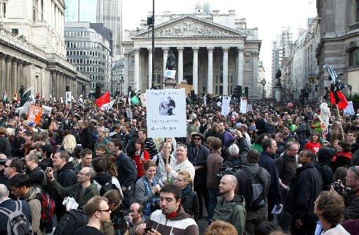 The crowd hold up placards outside the Bank of England