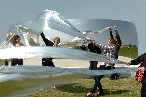 Children from Patcham High School experiment with foil sheets by the C Curve installation.