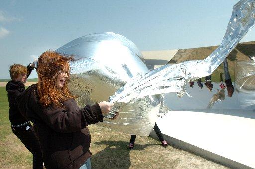 Children from Patcham High School experiment with foil sheets by the C Curve installation.