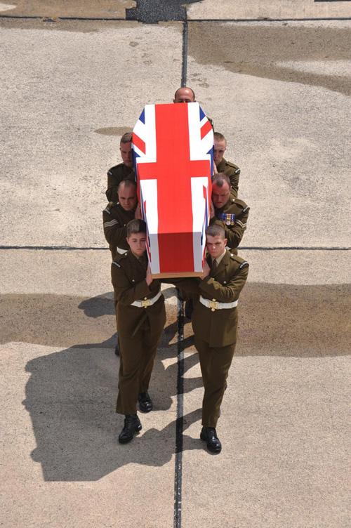 Soldiers carry Guardsman Brackpool's coffin as it is returned to UK soil.