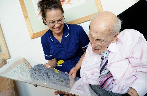 Henry Allingham with Julie Millward, Senior Staff Nurse as she reads a copy of The Argus published on Mr Allingham's birthday.