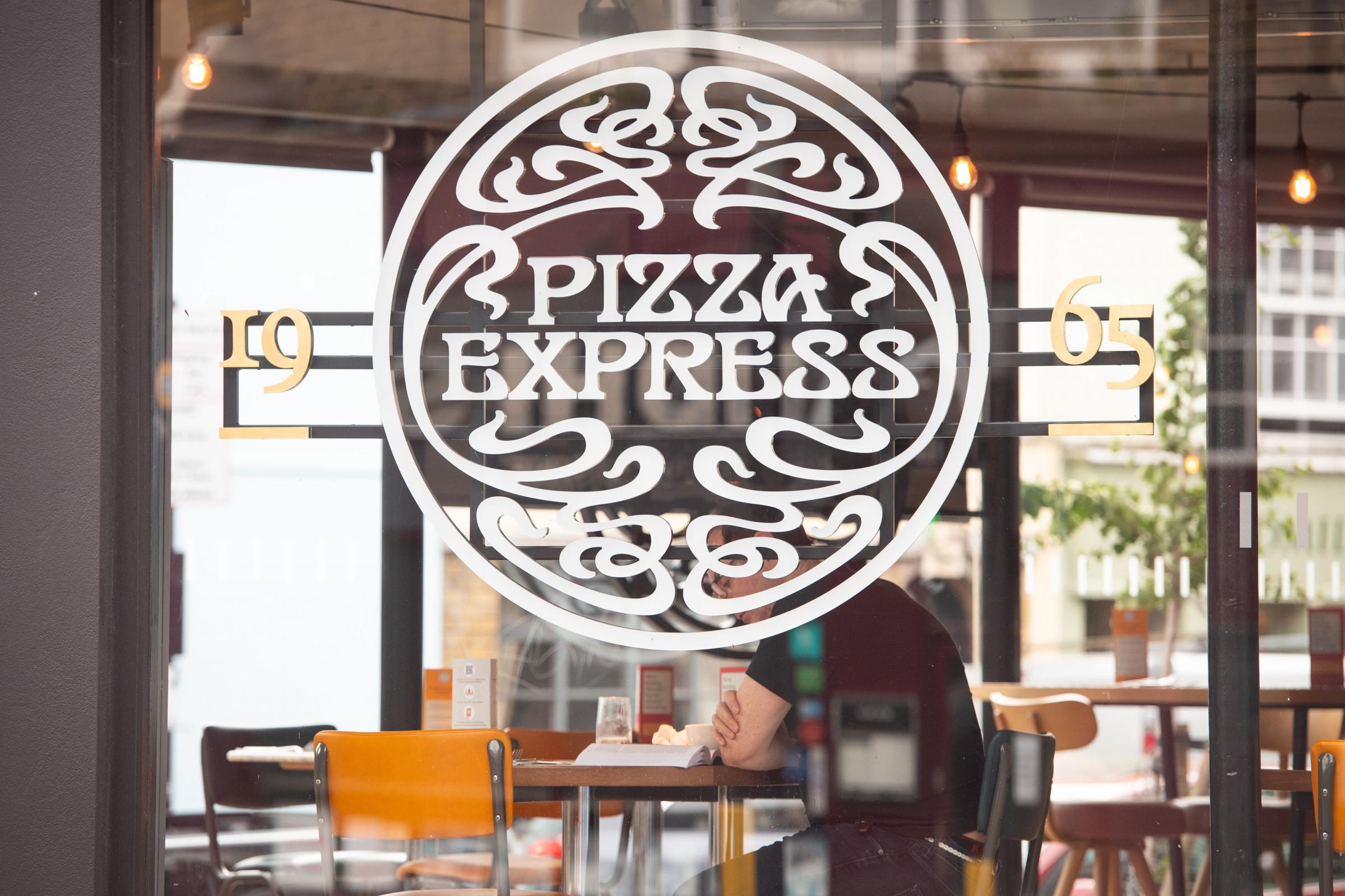 File photo dated 04/08/20 of a customer dining at a branch of Pizza Express in London, as the restaurant chain has announced that it is to shut 73 of its restaurants across the UK with the potential loss of 1,100 jobs in a bid to stay afloat in the wake