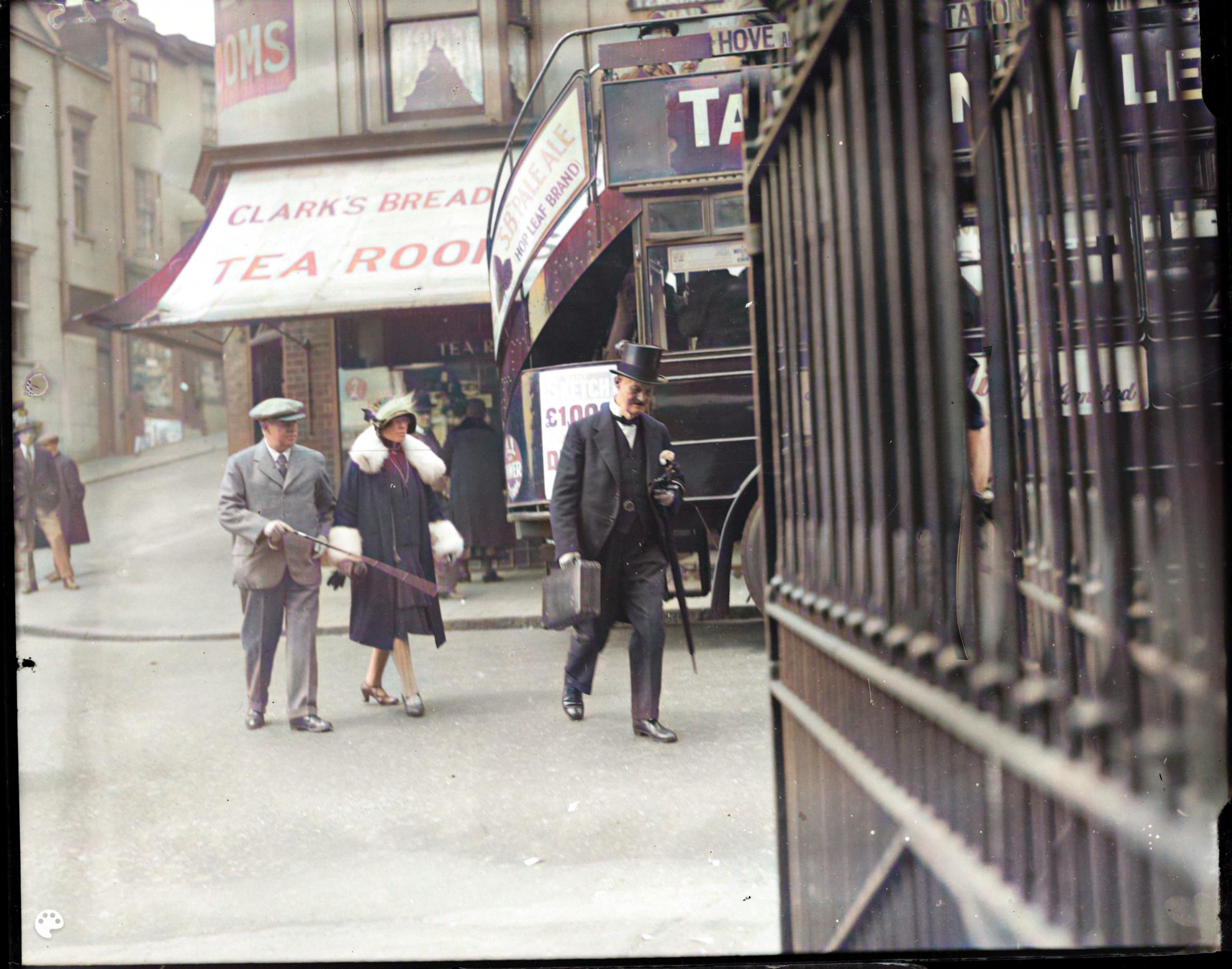 Three very smart people crossing the road near Brighton Station in 1929. Note the open-top bus on the right