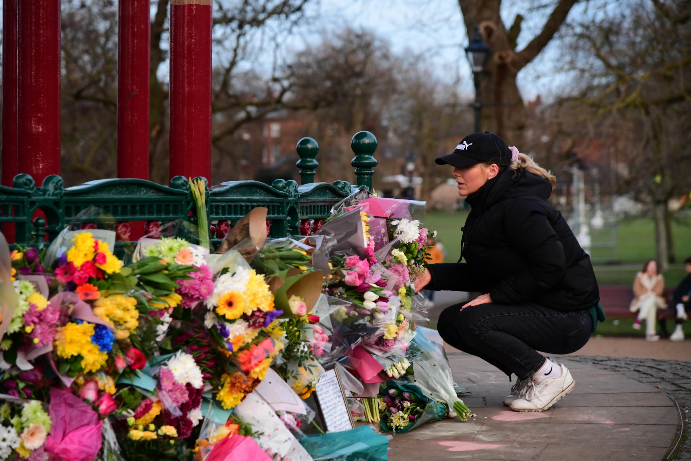 A woman leaves flowers at the bandstand on Clapham Common, after a body found hidden in woodland in Kent has been identified as that of 33-year-old Sarah Everard. A serving Metropolitan Police officer, who is aged in his 40s, remains in custody on