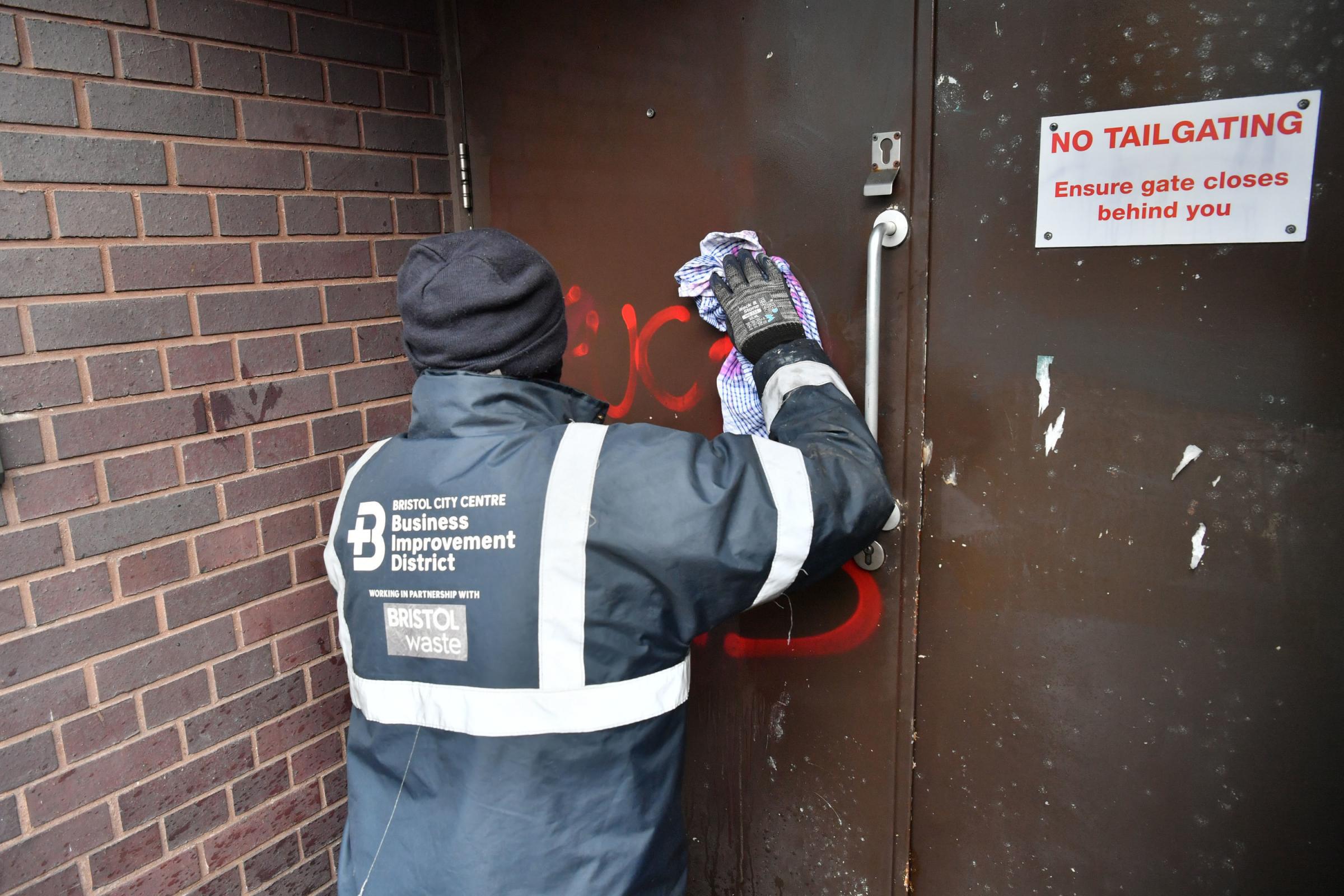 A worker from the Bristol BID Team cleans graffiti outside of Bridewell Police Station in Bristol. Protesters broke windows and vandalised the police station on Sunday after demonstrating against the Governments controversial Police and Crime Bill.