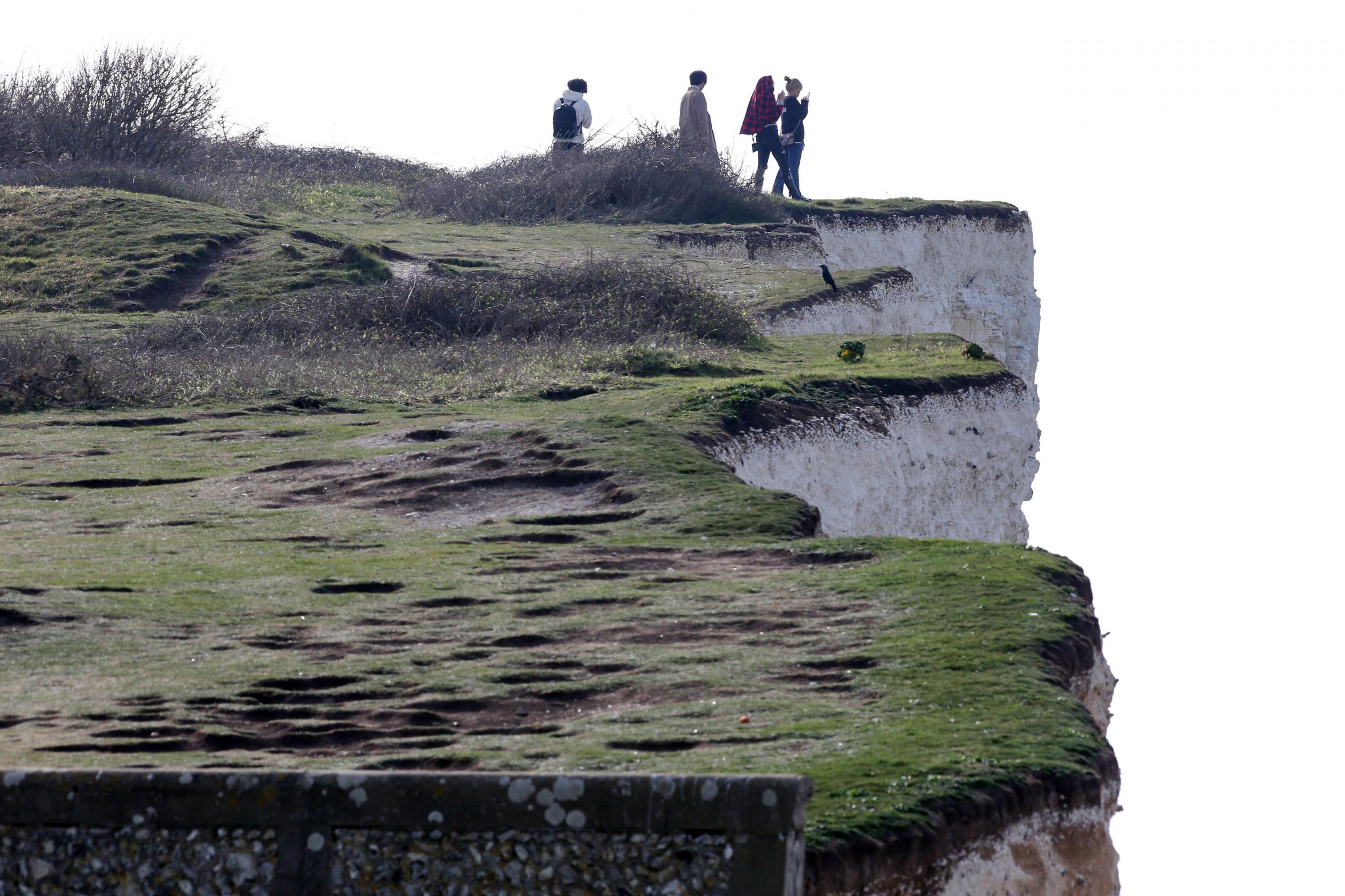 People were pictured peering over the cliff edge at Birling Gap Credit: Eddie Mitchell