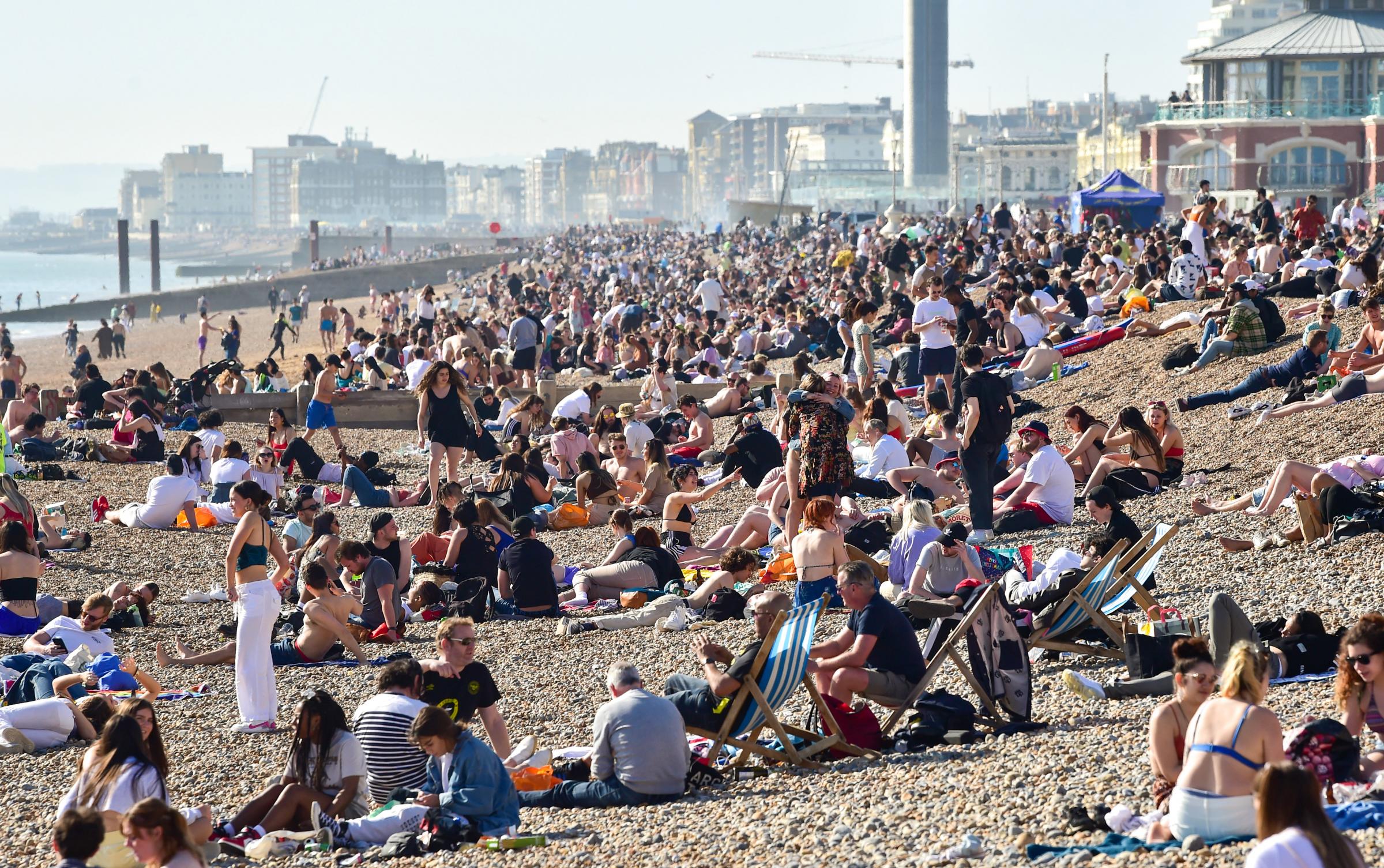 Brighton UK 30th March 2021 - Brighton beach is packed as visitors flock to the seaside on the hottest day of the year so far with temperatures reaching the mid 20s centigrade in parts of the South East : Credit Simon Dack / Alamy Live News.........