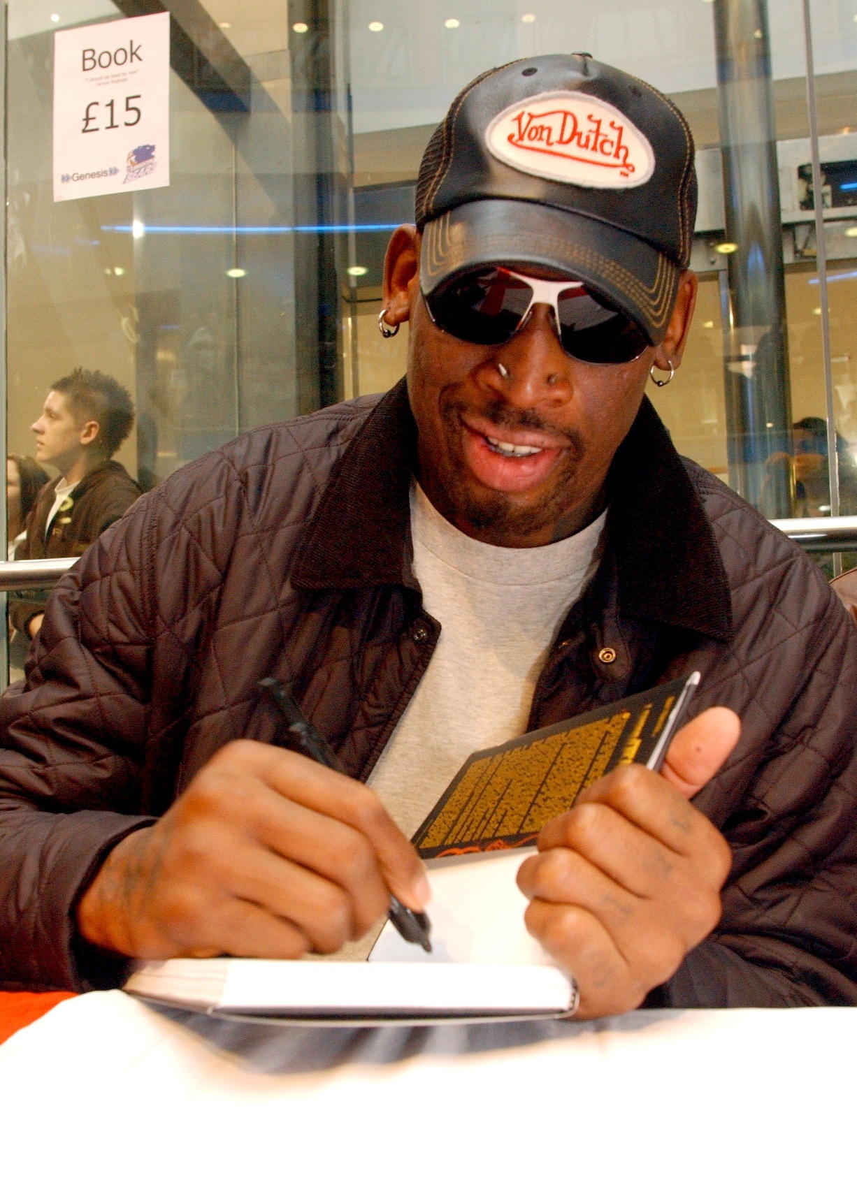 Dennis Rodman signs his book at Churchill Square, Brighton, and, right, he is mobbed as he comes off the court after the Brighton Bears v Guildford heat 