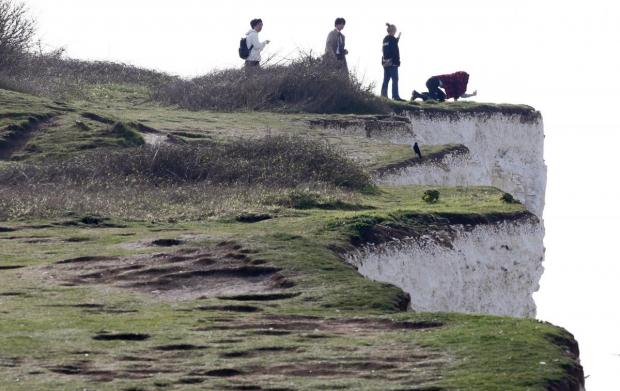 The Argus: People pictured on the edge of cliffs at Birling Gap earlier this year. Photo: Eddie Mitchell