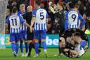 Albion players question the red card shown to Lewis Dunk after (inset) he appeared to be apologetic for his comment to Anthony Taylor