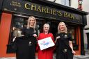 Una Burns (left), manager of Charlie’s Bar Enniskillen and Sarah Thompson (right), founder of embroidery company Ted & Stitch with Siobhan Casey from Age NI (Fiona Brown Communications/PA)