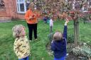 The children hang their bird feeders in a tree at the care home