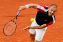 Britain’s Daniel Evans serves against Denmark’s Holger Rune during their first round match of the French Open tennis tournament at the Roland Garros stadium in Paris, Tuesday, May 28, 2024. (AP Photo/Christophe Ena)
