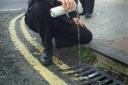 DOWN THE DRAIN: Police during an anti-street drinking campaign in Kemp Town in 2001