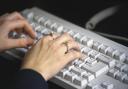 A woman works at keyboard