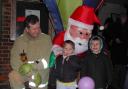 Henfield fire service watch commander Paul Smith with James Melville and George Dean, both 4, outside Santa's grotto in Henfield