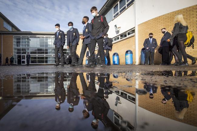 Students walk near a puddle at a school