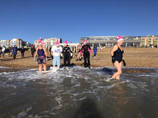 The Argus: Women and men sporting bikinis, shorts, wet suits, fancy dress and even a mankini took to the cold water in Hove to launch a Chrismas swim advent event.